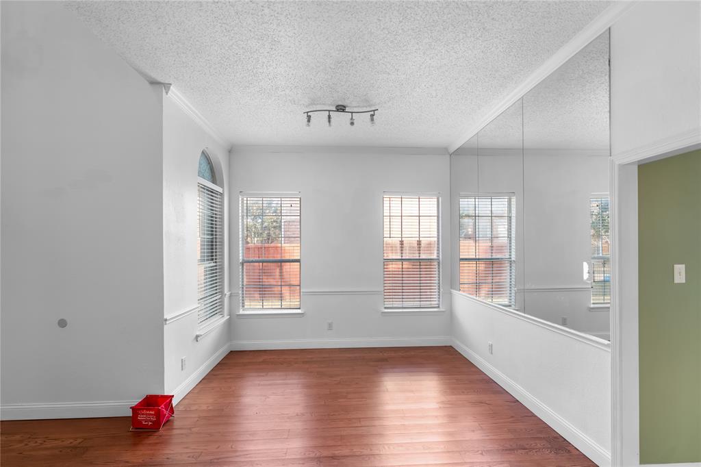 9447 Abbey Road Irving, TX 75063 - Photo 7 of 40 a view of an empty room with wooden floor and a window