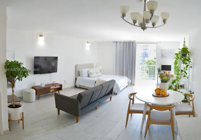 a living room with furniture potted plant and a flat screen tv