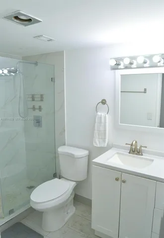 a bathroom with a toilet sink vanity and mirror