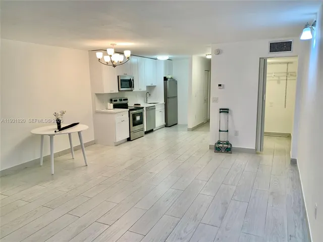 a view of a kitchen with a sink and a refrigerator