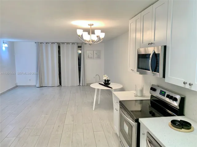 a kitchen with a sink dishwasher a stove and a refrigerator with wooden floor