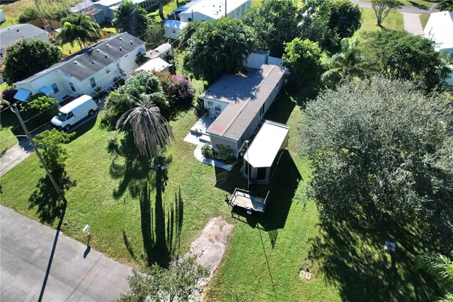 an aerial view of residential house with outdoor space and trees all around