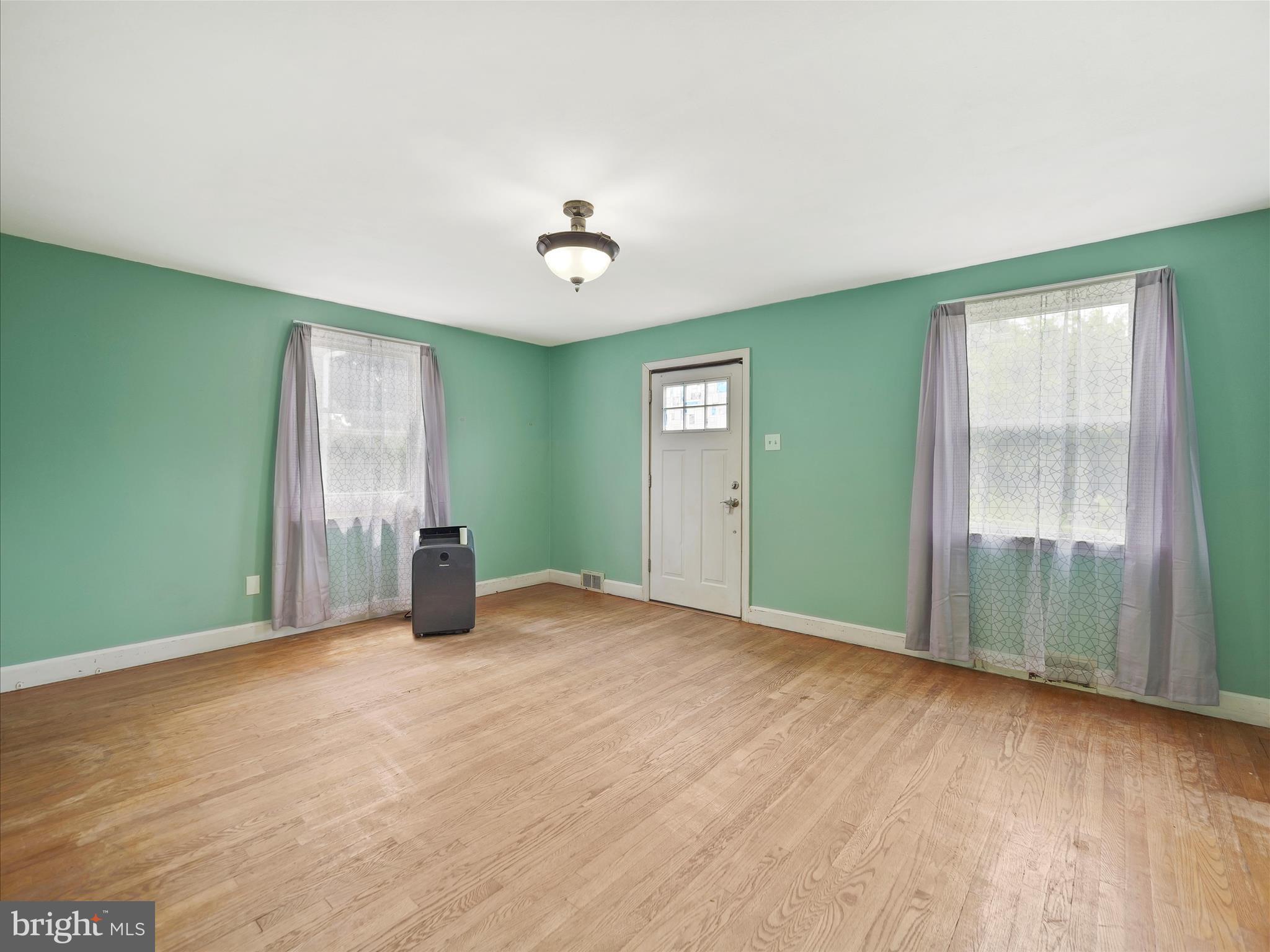 224 Devonshire Road Hagerstown, MD 21740 - Photo 8 of 28 a view of an empty room with window and wooden floor
