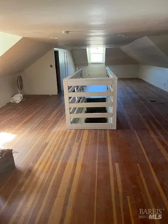 a view of a room with wooden floor and a window