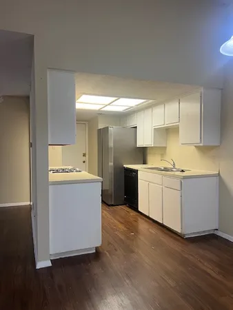 a large kitchen with a lot of counter space and wooden floor