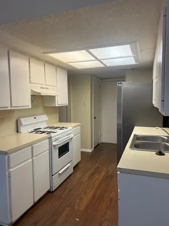 a kitchen with a stove sink and cabinets