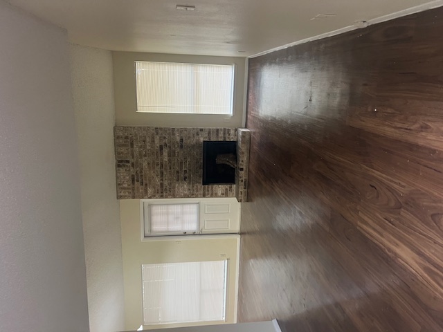 11429 Ptarmigan Drive, Unit B Austin, TX 78758 - Photo 7 of 27 an empty room with wooden floor fireplace and windows