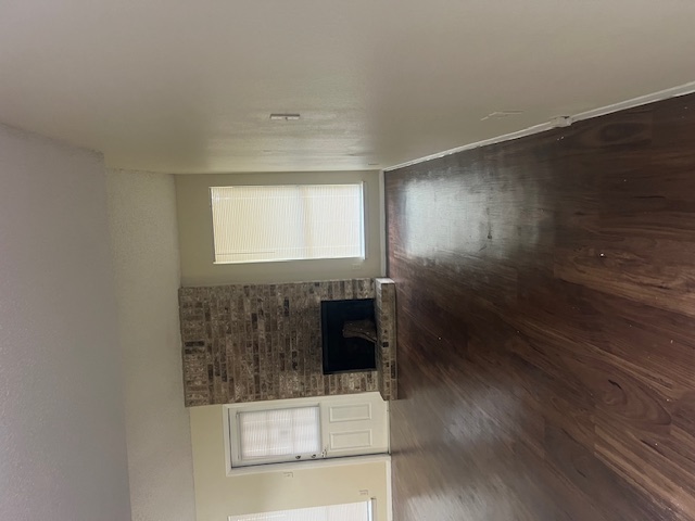 11429 Ptarmigan Drive, Unit B Austin, TX 78758 - Photo 8 of 27 an empty room with wooden floor fireplace and windows
