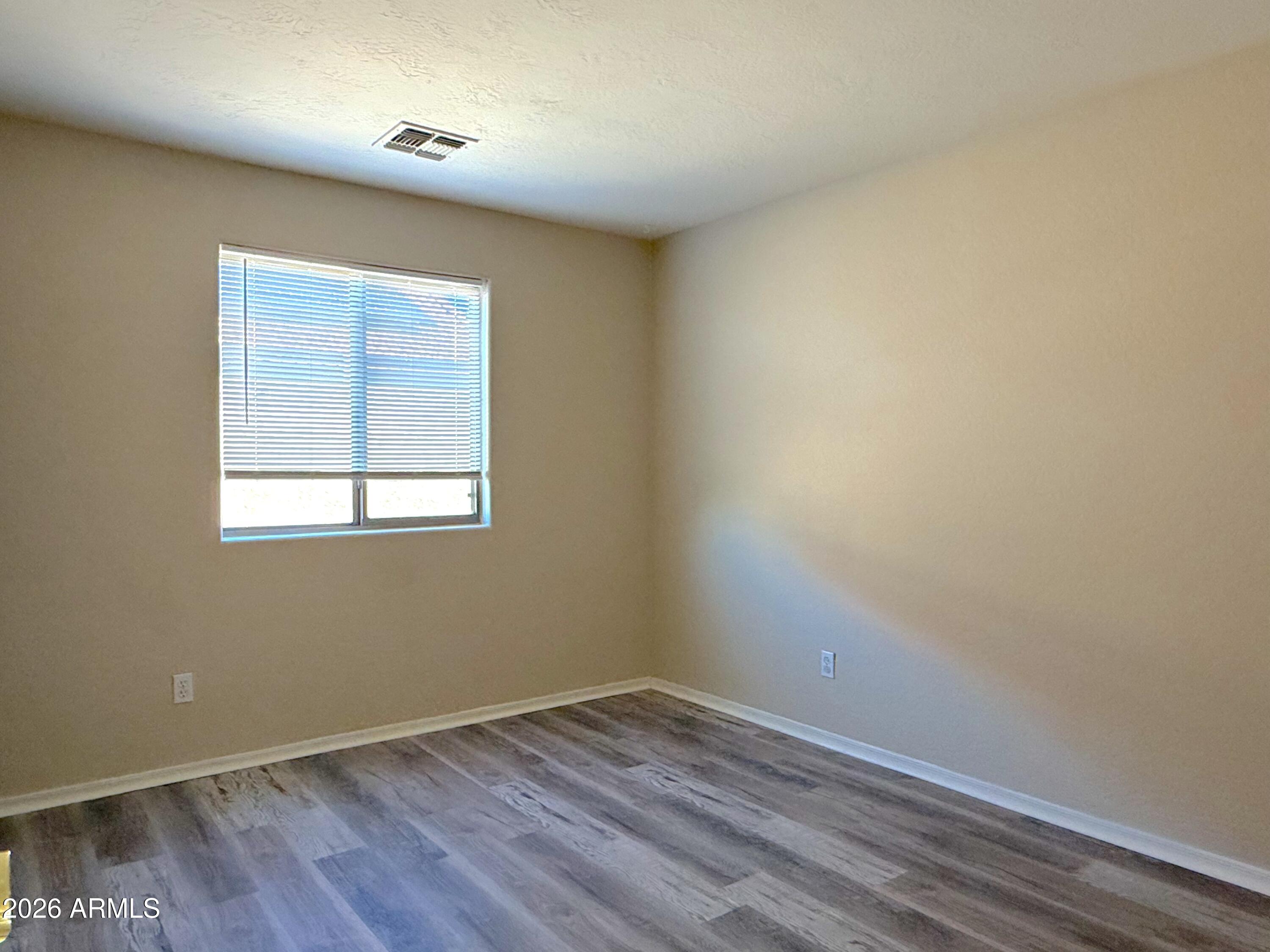 3545 East Crescent Way Gilbert, AZ 85298 - Photo 15 of 19 an empty room with wooden floor and windows
