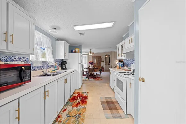 a large kitchen with stainless steel appliances granite countertop a lot of counter space and a sink