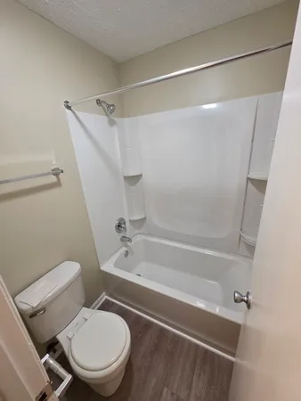 a white toilet and tub sitting next to a bathroom sink