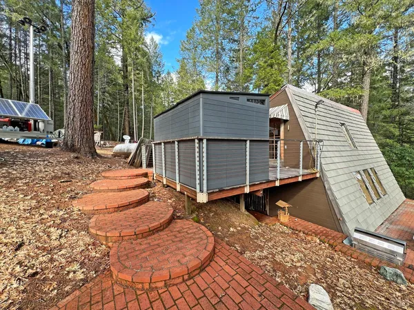 a backyard of a house with barbeque oven and wooden fence