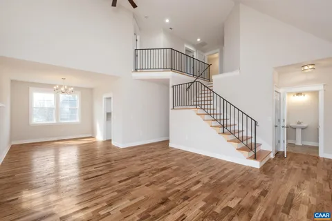 an empty room with wooden floor windows and fireplace