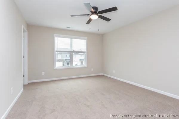 an empty room with a window and a fan