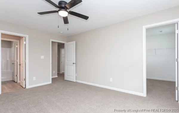 a view of a room with a ceiling fan and a ceiling fan