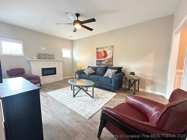 a living room with furniture a fireplace and a window