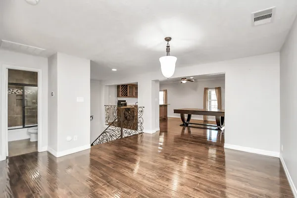 a view of a room with wooden floor table and chairs