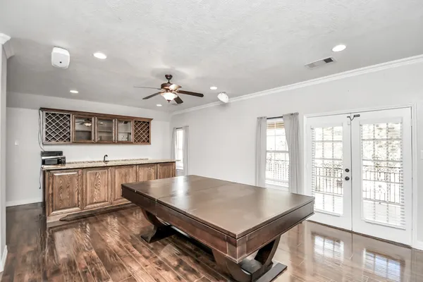 a living room with stainless steel appliances furniture large window and wooden floor