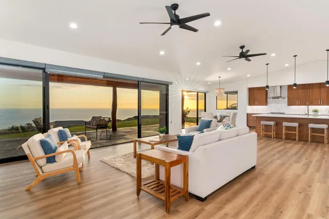 a kitchen with stainless steel appliances granite countertop a stove top oven a dining table and chairs with wooden floor