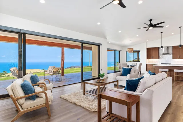 a living room with furniture and floor to ceiling windows
