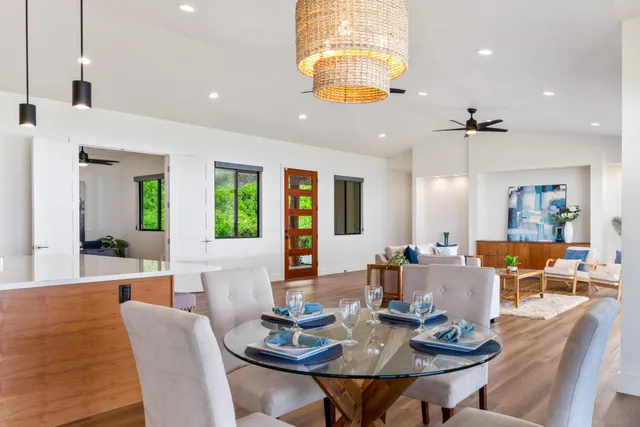 a living room with furniture kitchen view and a large window