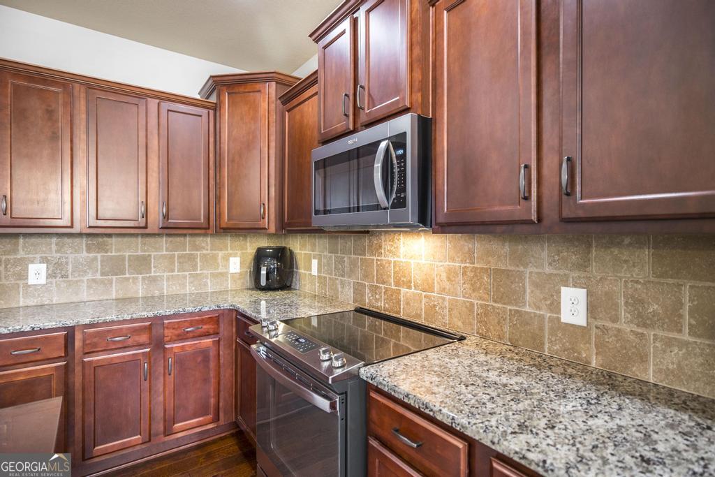 400 Ansley Avenue Perry, GA 31069 - Photo 14 of 37 a kitchen with granite countertop cabinets stainless steel appliances and a counter space