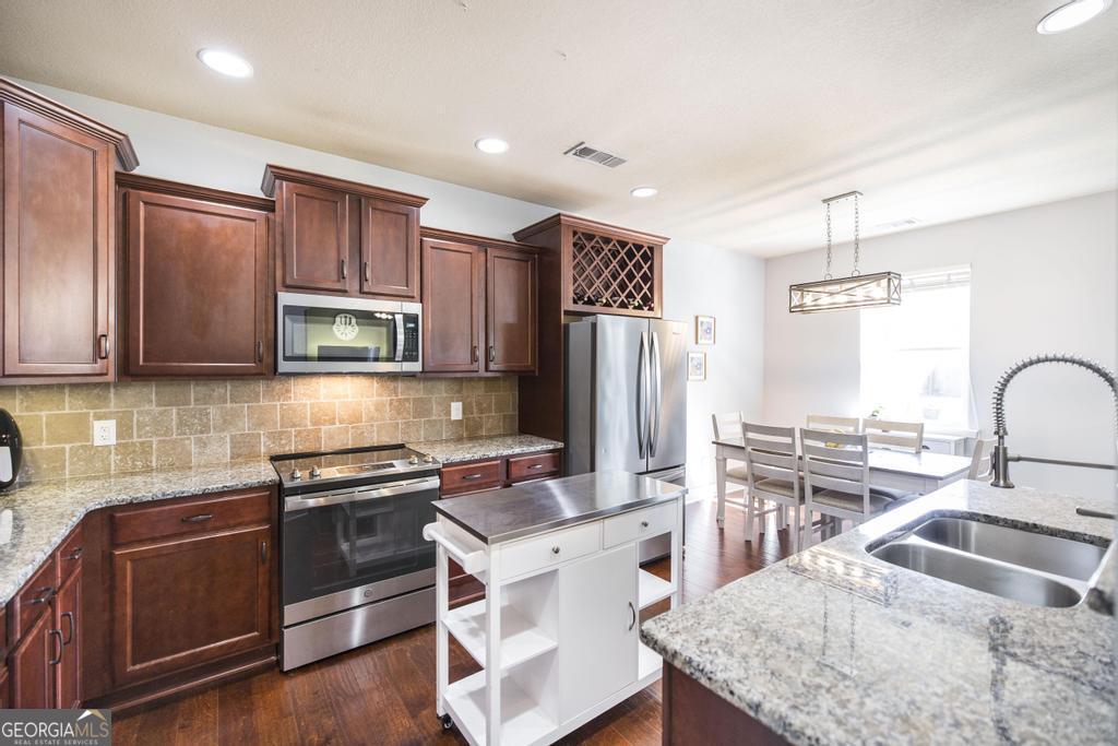 400 Ansley Avenue Perry, GA 31069 - Photo 16 of 37 a kitchen with stainless steel appliances granite countertop a sink stove and refrigerator