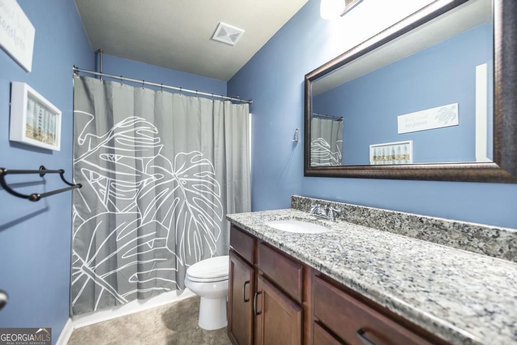 400 Ansley Avenue Perry, GA 31069 - Photo 23 of 37 a bathroom with a granite countertop sink and a mirror