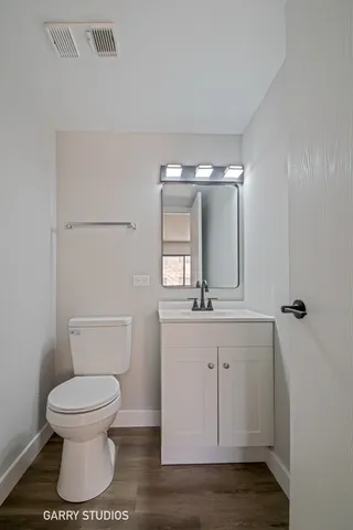a bathroom with a toilet a sink and mirror