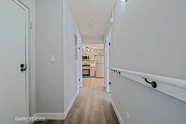 a view of a hallway with wooden floor and closet