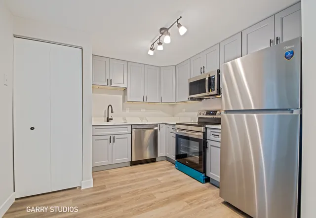 a kitchen with cabinets stainless steel appliances and a refrigerator