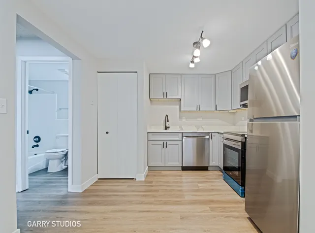 a kitchen with a refrigerator sink and cabinets
