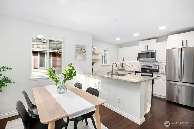 a kitchen with refrigerator and chairs