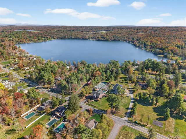 an aerial view of house with yard and ocean view