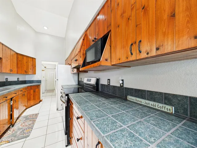 a kitchen with stainless steel appliances granite countertop a sink a stove and a refrigerator