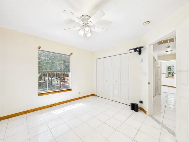 an empty room with windows and fan