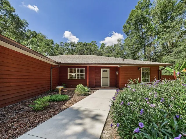 a backyard of a house with table and chairs