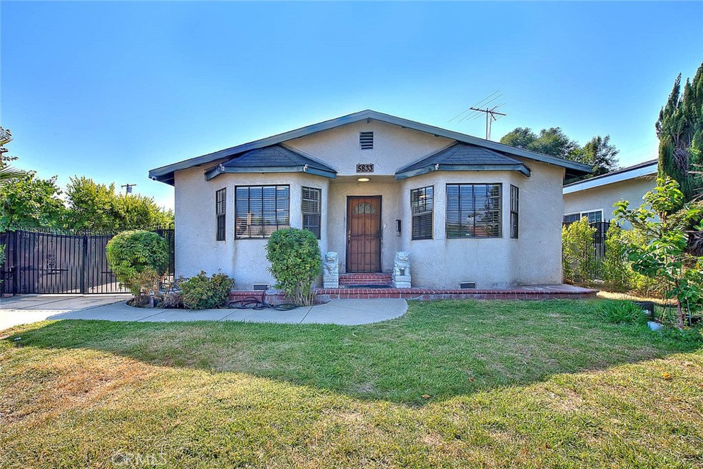 a front view of a house with a yard and potted plants