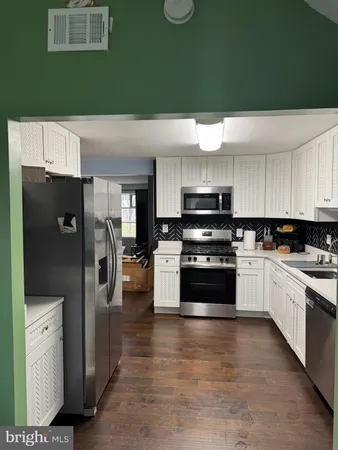 a kitchen with stainless steel appliances a refrigerator stove and sink