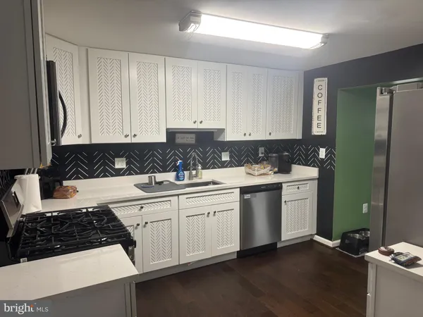 a kitchen with stainless steel appliances granite countertop a sink stove and cabinets