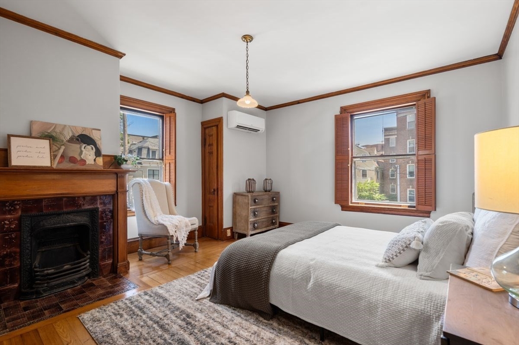 35 Langdon Street Cambridge, MA 02138 - Photo 11 of 35 a bedroom with a bed a fireplace and a window