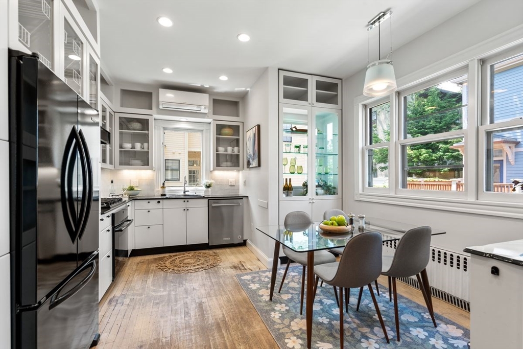35 Langdon Street Cambridge, MA 02138 - Photo 7 of 35 a kitchen with stainless steel appliances granite countertop a stove top oven a refrigerator a dining table and chairs with wooden floor