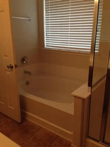 a bathroom with a bathtub and a window