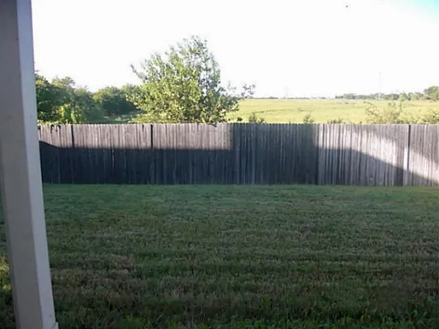 a view of a backyard with wooden fence