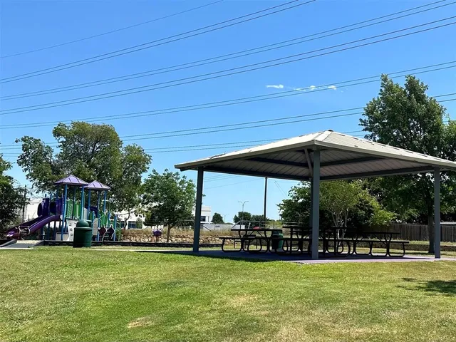 a view of a swimming pool with lawn chairs under an umbrella