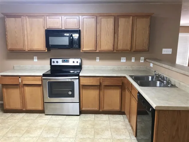 a kitchen with stainless steel appliances a stove a sink a microwave and cabinets
