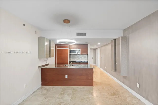 a view of kitchen with kitchen island stainless steel appliances a sink and cabinets