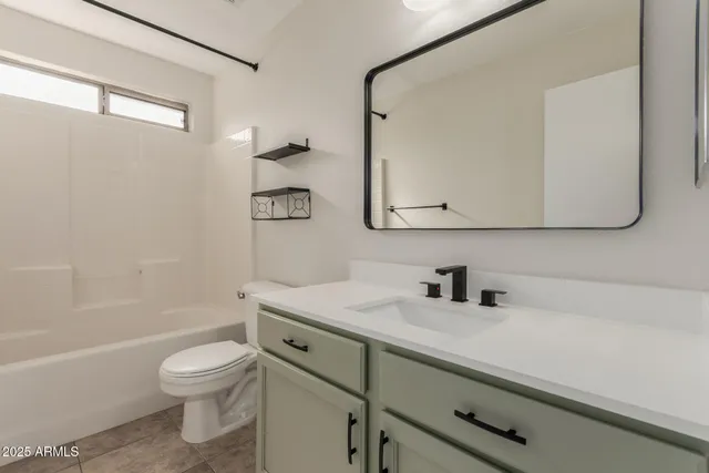 a white toilet and tub sitting next to a bathroom sink
