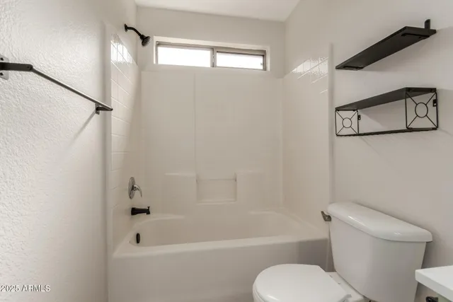 an empty room with a window and a ceiling fan