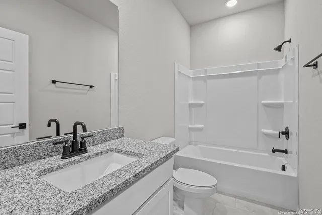 a bathroom with a granite countertop sink a toilet and a bathtub